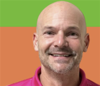 Man with multicolored background smiling at the camera